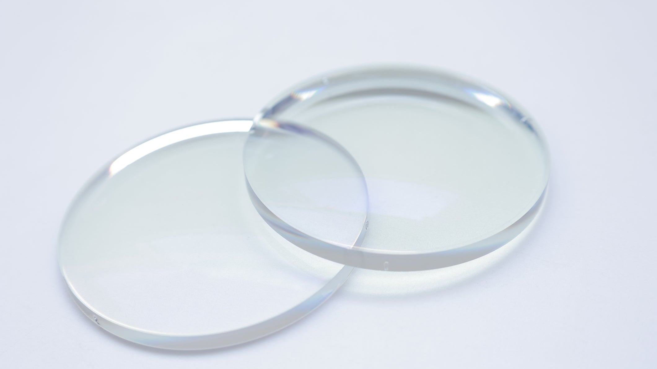 Δύο λεπταίνοντες φακοί γυαλιών σε λευκό φόντο για σύγκριση πάχους
